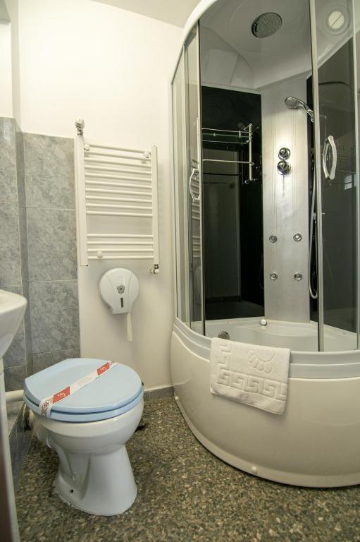 Baie modernă cu cadă hidromasaj și duș